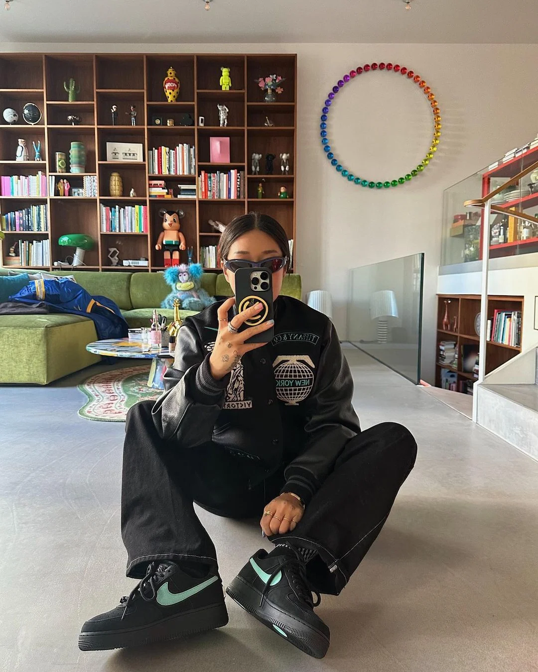 Contemporary Design Living Room With A Custom Wood Bookcase And With A Green Sofa And With A Geometric Rug